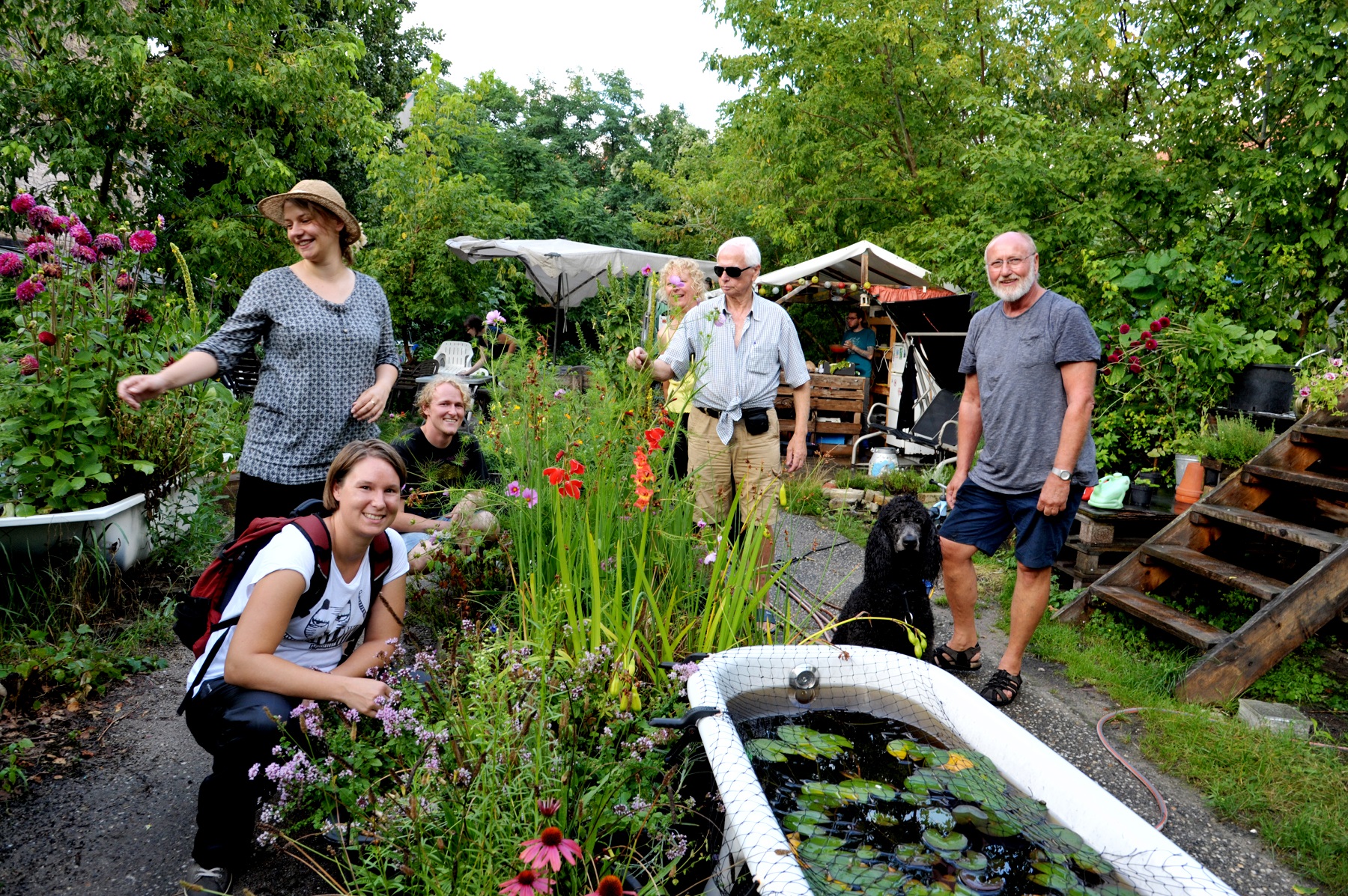 Die Stadtgärtner der Prachttomate in Neukölln. In der Bornsdorfer Straße 9 -11 in Berlin Neukölln.  Das Urban-Gardening-Projekt gibt es schon seit 2011. Auf dem Foto sind die Gärtner: Vanessa und Anja. und mit lockigem Haar Johannes und mit Sonnenbrille ganz cool Achim. Paar mit Hund ist zu Besuch. - leider sind nach dem Unwetter nur wenig Leute zum shooting gekommen. Deike beschreibt im Text viel mehr exotische Leute. Foto: Doris Spiekermann-Klaas